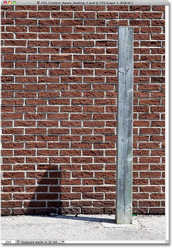 A photo of a wooden post casting a shadow against a brick wall. Image © 2010 Steve Patterson, Photoshop Essentials.com