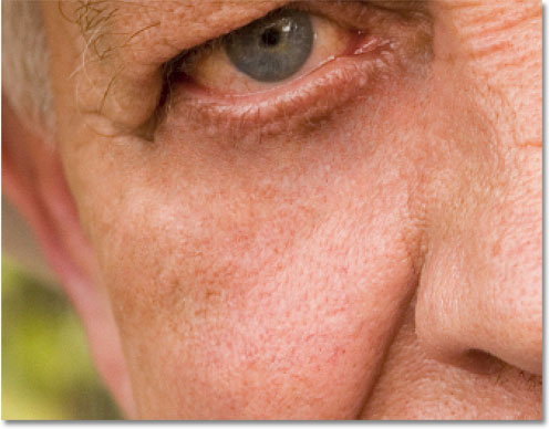 Continuing to remove the larger wrinkle under the man's eye with the Healing Brush. Image © 2010 Photoshop Essentials.com