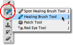 Memilih Healing Brush dari panel Tools di Photoshop CS5. Image © 2010 Photoshop Essentials.com