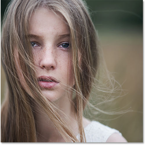 Portrait of a beautiful blonde girl in a field in spring  Still life mage licensed from Shutterstock by Photoshop Essentials.com