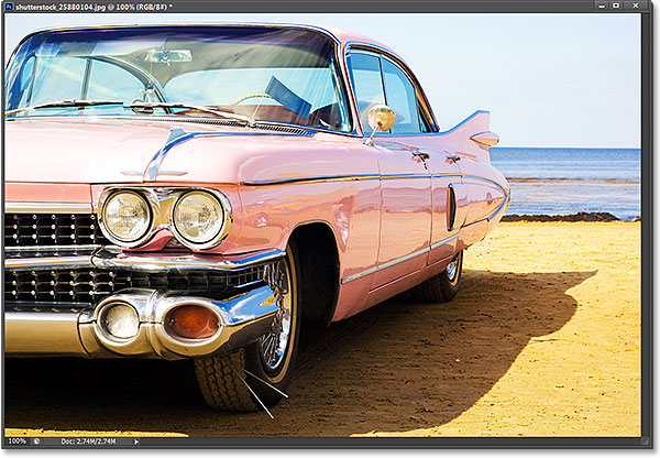 Mobil merah muda klasik di pantai. Foto berlisensi dari Shutterstock oleh Photoshop Essentials.com