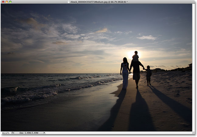 A family walking on the beach at sunset. Image licensed from iStockphoto by Photoshop Essentials.com.