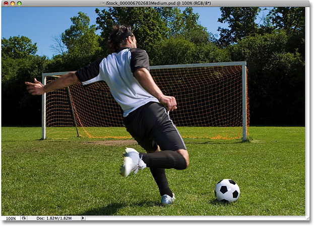 Sebuah foto dari pemain sepak bola akan menendang bola ke jaring. Gambar berlisensi dari iStockphoto oleh Photoshop Essentials.com.