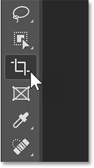 Selecting the Crop Tool in Photoshop's toolbar.