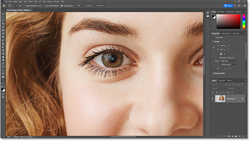 Zooming in closer to the woman's eye with Photoshop's Zoom Tool.