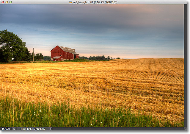 An HDR photo of a red barn in a field. 