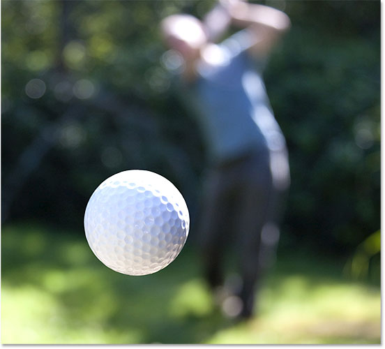 A golf ball in flight. Image #24403595 licensed from Adobe Stock by Photoshop Essentials.com