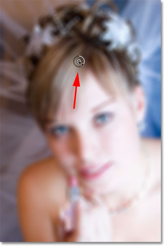 Dragging the initial pin away from the woman's eyes in the photo. Image © 2012 Photoshop Essentials.com