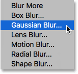 Choosing the Gaussian Blur filter from under the Filter menu. Image © 2016 Steve Patterson, Photoshop Essentials.com