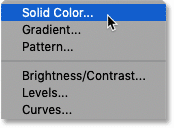 Selecting a Solid Color fill layer in Photoshop's Layers panel.