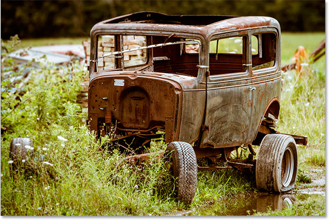 An old, rusted vintage car.