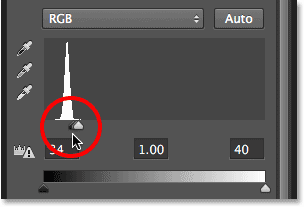 Dragging the black point slider towards the right.