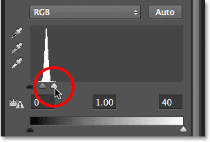 Dragging the white point slider towards the left.