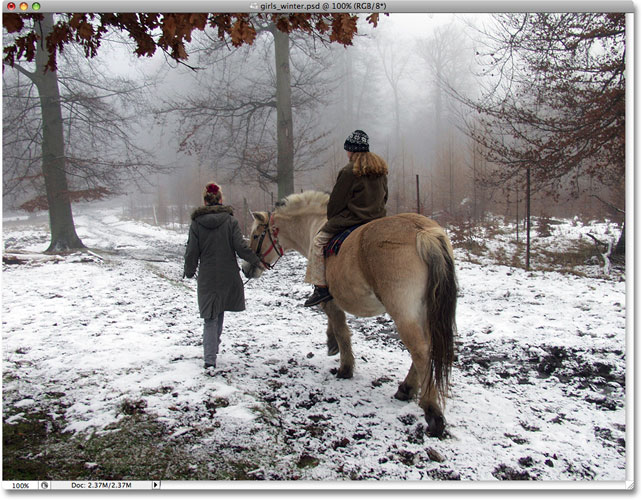 The original photo of two girls with a horse walking through the snow. Image licensed from iStockphoto by Photoshop Essentials.com.