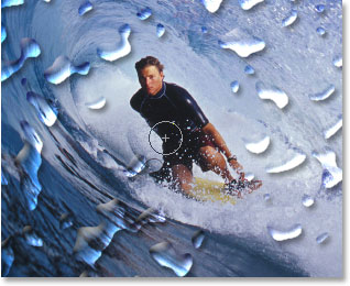 Erasing the water drops in front of the surfer with the Eraser Tool.